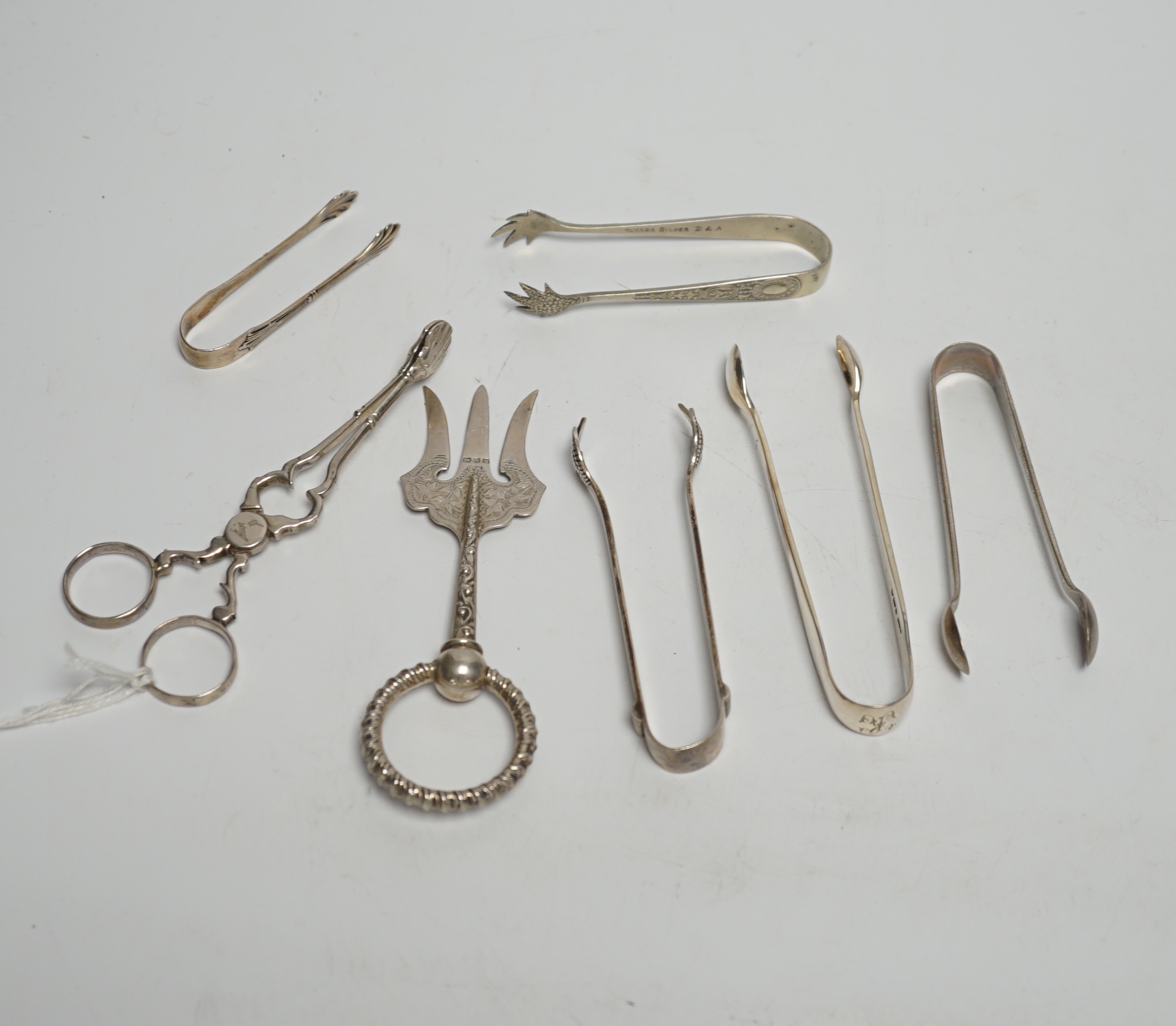 A pair of 18th century Irish silver sugar nips, together with sixteen later mainly 20th century silver sugar nips, various dates and makers, eight plated pairs and a small silver toasting? fork.